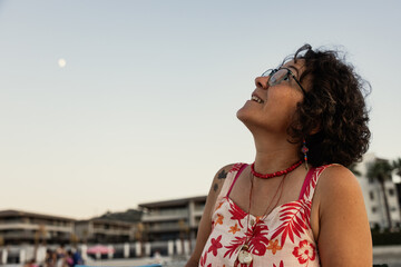 Portrait of a happy senior woman at the beach at sunset