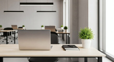 Modern Open-Plan Office Interior with a Laptop on a Clean Wooden Desk, Brightly Lit by Natural Light, Symbolizing a Productive and Professional Digital Workspace.