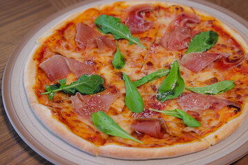 Artisan Pizza Delight: A close-up shot of an appetizing artisan pizza, garnished with fresh arugula and succulent cured ham, inviting taste buds.