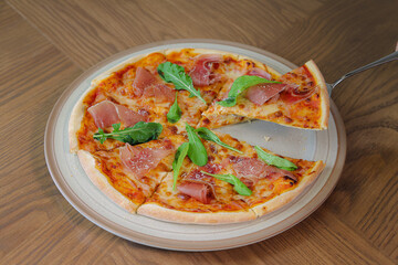 Savory Slice: A freshly baked pizza is lifted from the whole pie showcasing the deliciousness of Italian cuisine.