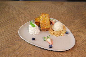 Toast Dessert Delight: A delicious toast dessert with ice cream, blueberries and strawberries with cream, offering a tempting gourmet experience.
