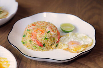 Shrimp Fried Rice Delight: A culinary masterpiece of shrimp fried rice, adorned with a vibrant slice of lime and a perfectly cooked fried egg, presenting a feast for the eyes and taste buds.