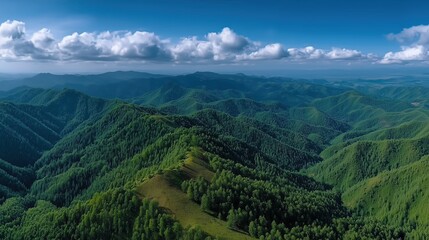 Aerial View of Lush Green Mountains Under Bright Blue Sky with Fluffy White Clouds