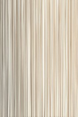Obraz premium A close-up depicts numerous vertical, pale beige fabric strands, possibly curtains or drapery, exhibiting subtle variations in tone and texture, creating a sleek, minimalist aesthetic
