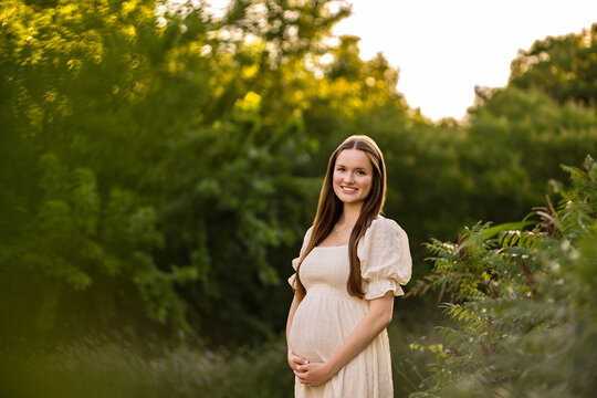 natural portrait of a mother to be in a field