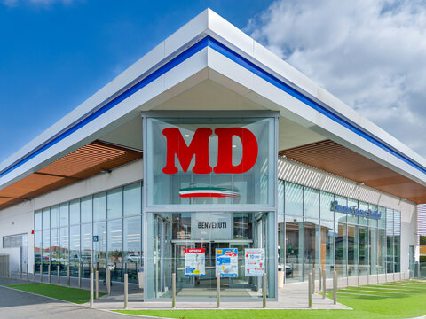 Verzuolo, Italy - September 18, 2025: building entrance with sign MD discount store logo on blue sky with white clouds, MD S.p.A. is Italian large-scale retail company.