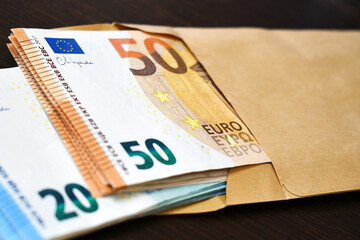 50 and 20 Euro banknotes in brown envelope on the table. Business and finance concept.