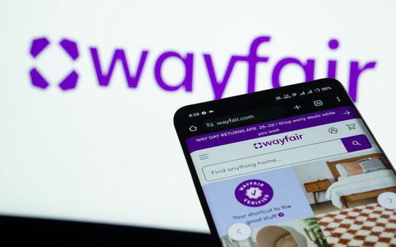 Dhaka, Bangladesh- 03 July 2025: Smartphone displaying Wayfair web interface against Wayfair logo background.