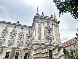 Obraz premium Panorama of the building of the old Palace of Justice of Bavaria against the background of a cloudy rainy summer sky.