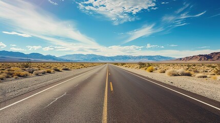 Desert road scenery Arid Serenity: Breathtaking Desert Road Scenery &ndash; A Long, Winding Asphalt Road Stretching Through Golden Sand Dunes and Scattered Desert Shrubs, Under a Clear Blue Sky