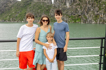 Happy european family, visiting Ha Long bay on a cruise with pool, visiting caves and landview...