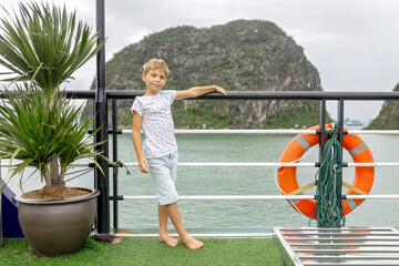Fototapeta premium Happy european family, visiting Ha Long bay on a cruise with pool, visiting caves and landview points