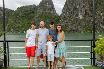 Happy european family, visiting Ha Long bay on a cruise with pool, visiting caves and landview...