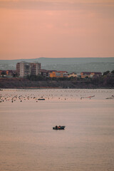 Small fishing boat on the Mar Piccolo of Taranto with mussel farm in the background