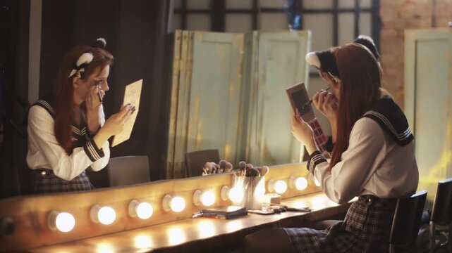 Young woman in cosplay costume applying makeup