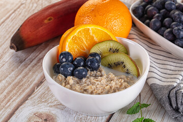 Oats porridge with blueberry, kiwi and orange