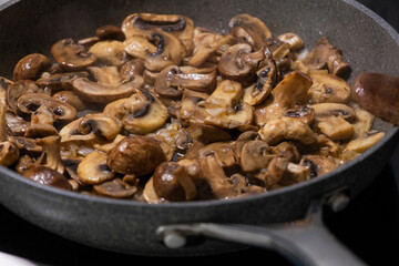 sliced mushrooms and onions sizzling in a hot pan