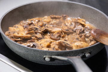 creamy mushroom sauce simmering in a pan with sautéed mushrooms and onions