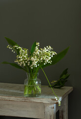Still life with a small bouquet of fragrant lilies of the valley.