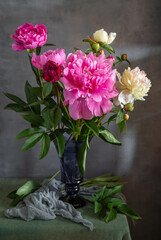 Still life with a bouquet of beautiful peonies in a glass vase.
