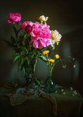 Still life with a bouquet of beautiful peonies in a glass vase.