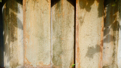 Closeup texture of an old weathered concrete wall showing vertical stains, moss growth, and rough cement surface. Perfect for backgrounds, industrial designs, rustic backdrops, or grunge style project