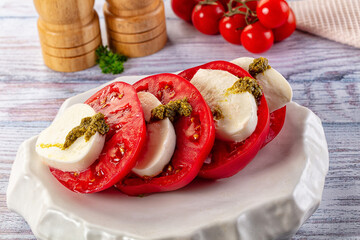 Italian Caprese salad with tomato, mozarella and pesto