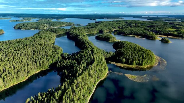 Explore the breathtaking landscapes of Punkaharju as the aerial perspective reveals the winding esker surrounded by tranquil lakes and dense forests. Punkaharju Nature Reserve Finland