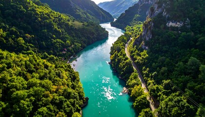 A high-angle view reveals a turquoise river winding through lush green valleys, surrounded by towering mountain ranges.