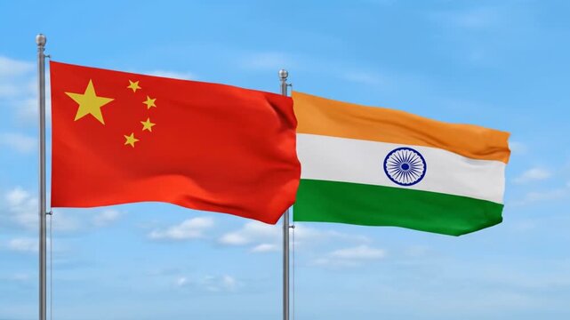 Two national flags waving in the wind the flag of china and the flag of india against a clear blue sky with clouds