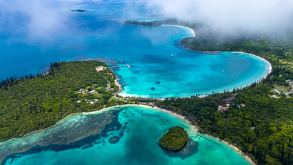 A beautiful aerial panorama of Kanumera Bay on the Isle of Pines, New Caledonia. Tall columnar...