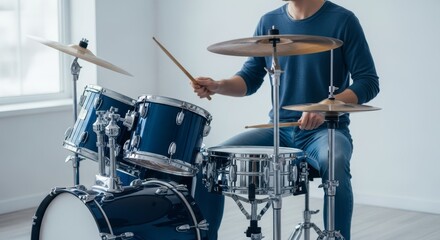 Young musician playing a blue drum kit indoors.
