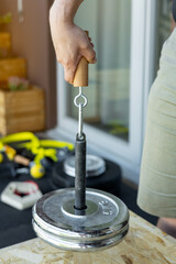Close-up of a male hand gripping a wooden handle during a sport-specific hammer curl for...