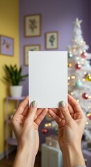 Obraz premium Woman hands holding blank white card mockup for Christmas or New Year greeting. Holiday celebration template for winter season message.