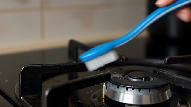 Cleaning gas stove burner with brush