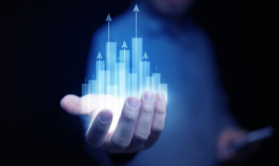Futuristic digital bar graph with arrows rising from a hand, symbolizing business growth, financial...