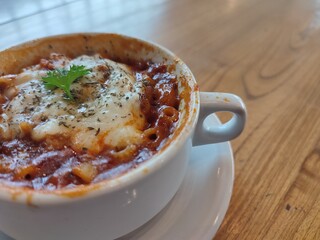Close-up of a delectable, bubbling baked pasta with rich tomato sauce and gooey melted mozzarella, elegantly served in a classic white ceramic dish, promising a savory culinary delight
