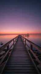 Obraz premium Serene sunrise over calm water, a wooden pier extends towards a distant structure, rocks flank the pier's edges, showcasing a tranquil, peaceful atmosphere