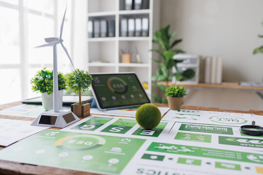esg small green ball symbolizing earth ESG environment, social,governance recycle sign on laptop screen with carbon free chart board in office
