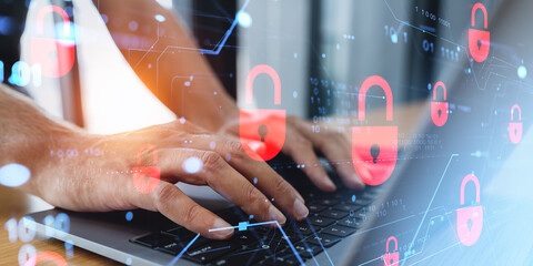 Hands typing on laptop with red padlock icons representing cybersecurity concept.