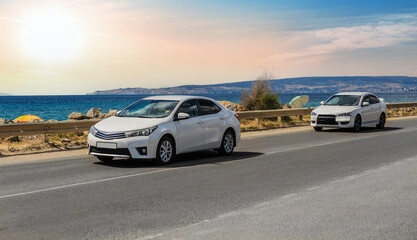 Fototapeta premium Cars drive along the road along the sea