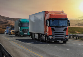 Trucks moving on a country highway against a beautiful sunset