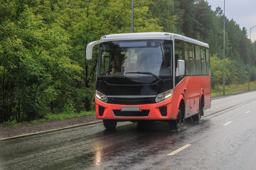 bus drives in the rain along a country road
