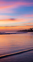 Vibrant sunset paints the sky with soft pinks and blues over a tranquil ocean and palm-lined coast