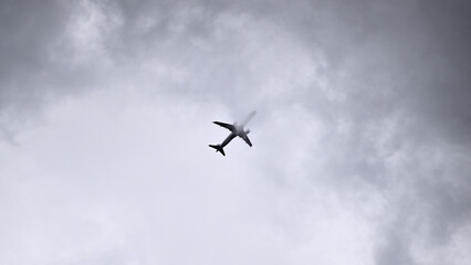 Airplane slicing through storm clouds with condensation