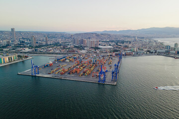 Naklejka premium Containers terminal in port with bridge cranes, aerial view. Logistics global trade infrastructure, Export and import in the sea