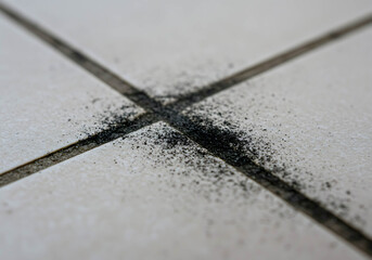 Black dirt accumulation on ceramic tile grout lines in kitchen  