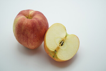 A vibrant display of natural goodness featuring a whole, crisp red and yellow striped apple next to a perfectly sliced half
