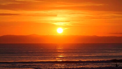 Fiery Sunset over Ocean and Distant Mountains