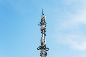 Fototapeta premium Global 5G network infrastructure: high-speed wireless communication tower under blue sky